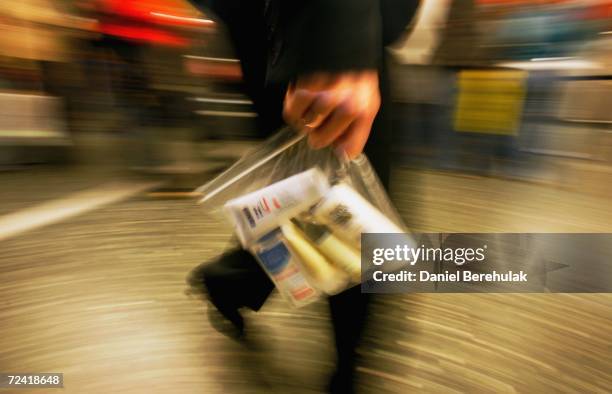 In this photo illustration a BAA employee carries a plastic bag with liquid containers consistent with new British airport security requirements for...
