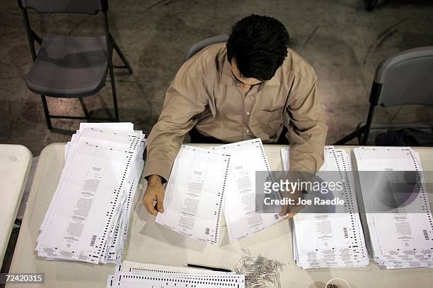 Election specialist, Anestis Konstantinidis, sorts through absentee vote ballots as he prepares them to be run through a tabulation machine November...