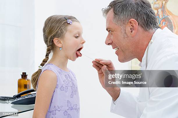girl having a check up with doctor - girl tongue doctor stockfoto's en -beelden