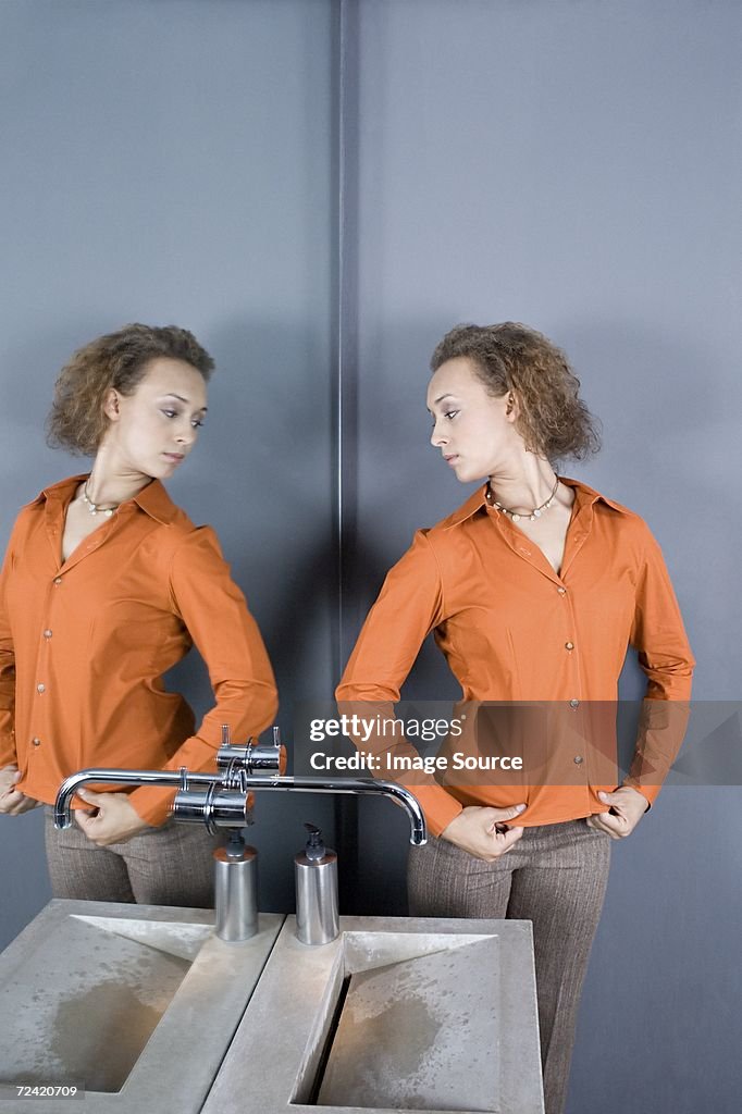 Donna guardando specchio in bagno