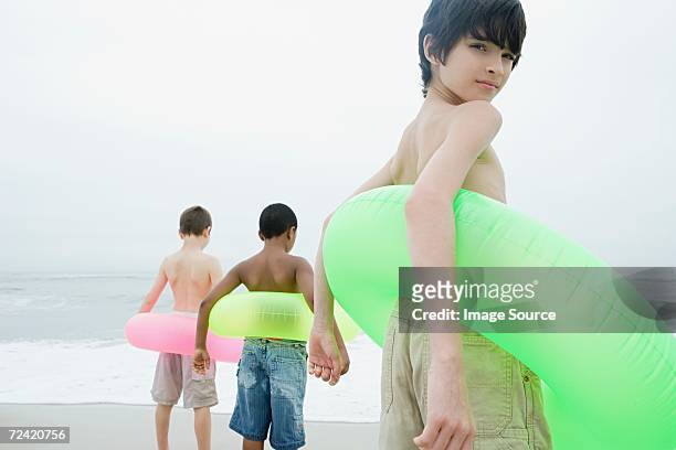 three boys wearing inflatable rings - boy river looking at camera stock pictures, royalty-free photos & images