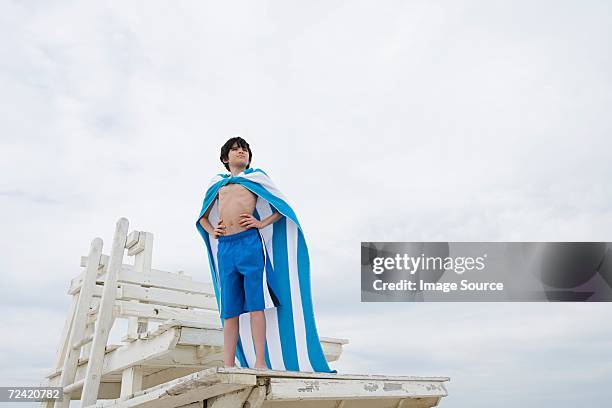 boy posing as a superhero - standing on chair stockfoto's en -beelden