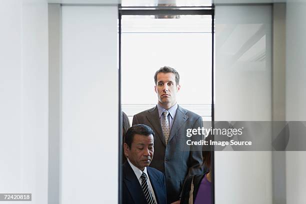 people in an elevator - crowded elevator stockfoto's en -beelden