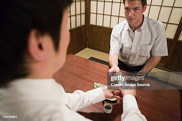 man serving saki - sake bottle stock pictures, royalty-free photos & images
