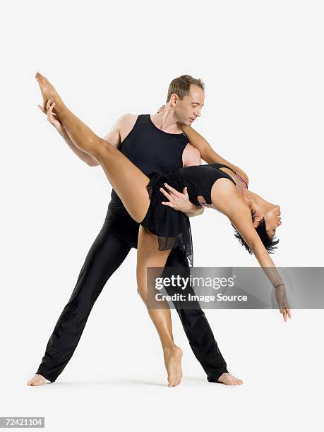 male dancer holding female dancer - ballroom dancers stock pictures, royalty-free photos & images