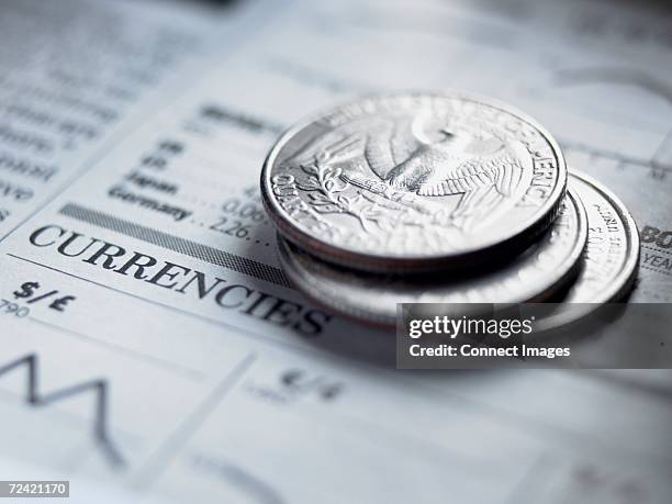 quarters on a newspaper - moneda de veinticinco céntimos fotografías e imágenes de stock
