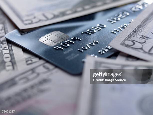 credit card amongst fifty dollar notes - fifty dollar bill stockfoto's en -beelden