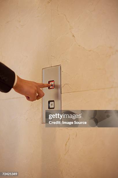 man pressing elevator button - push elevator button stock pictures, royalty-free photos & images