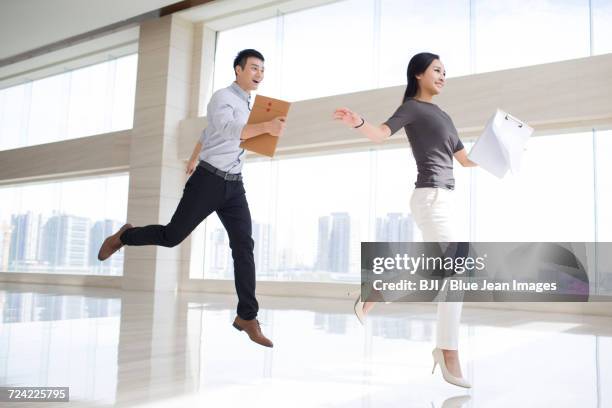 young business person jumping in office building - woman straddling man fotografías e imágenes de stock