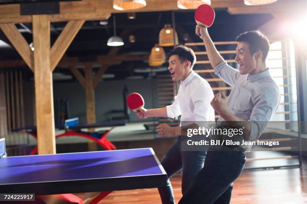 young businessmen playing ping pong - table tennis stock pictures, royalty-free photos & images