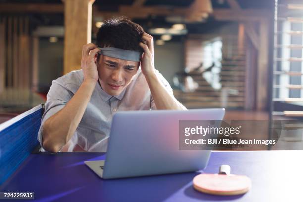 young businessman using laptop on table tennis table - funny ping pong stock pictures, royalty-free photos & images