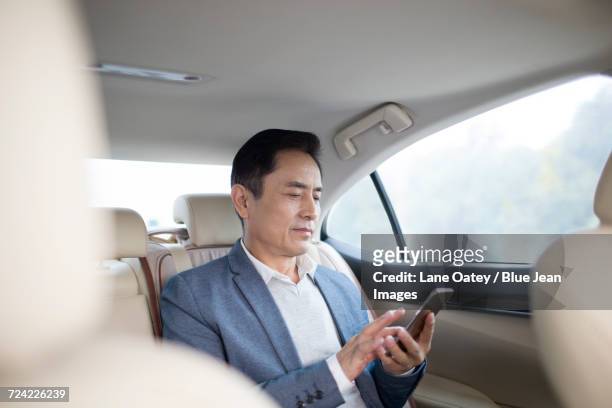 businessman using smart phone inside car - management car smartphone stock-fotos und bilder