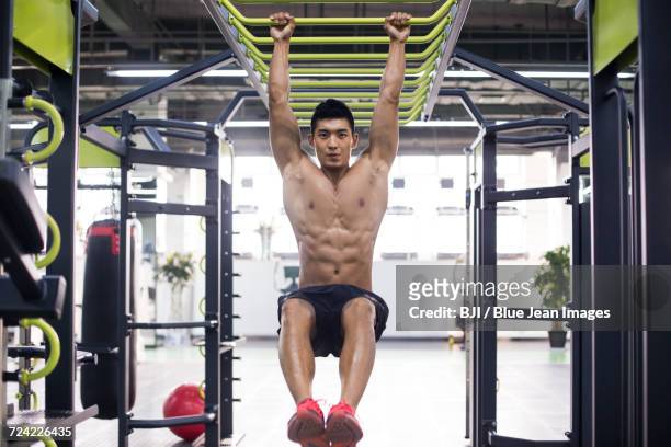 young man exercising at gym - brustmuskulatur stock-fotos und bilder