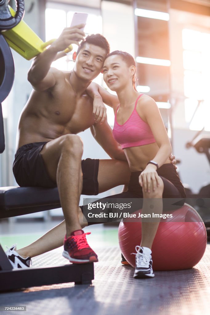 Young couple taking self portrait in the gym