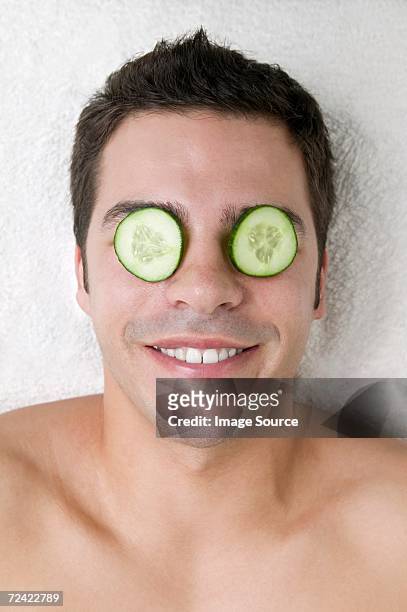 man with cucumber slices on his eyes - compassionate eye stockfoto's en -beelden
