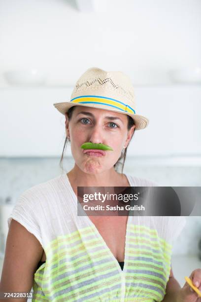 portrait of mid adult woman in straw hat and pea pod moustache - straw lips stock pictures, royalty-free photos & images