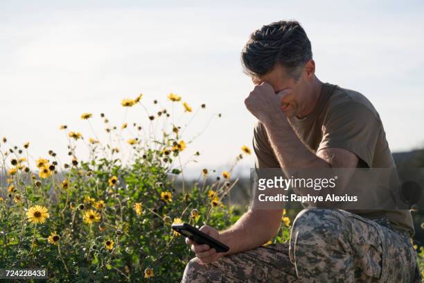 soldier wearing combat clothing looking at smartphone, runyon canyon, los angeles, california, usa - runyon canyon stock pictures, royalty-free photos & images