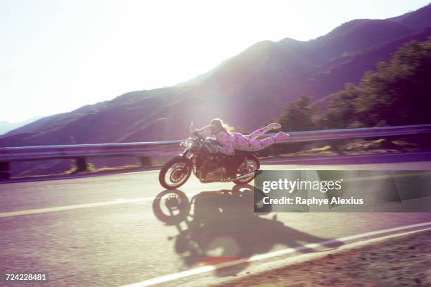 man wearing pink onesie riding motorcycle, malibu canyon, california, usa - out of context stock pictures, royalty-free photos & images