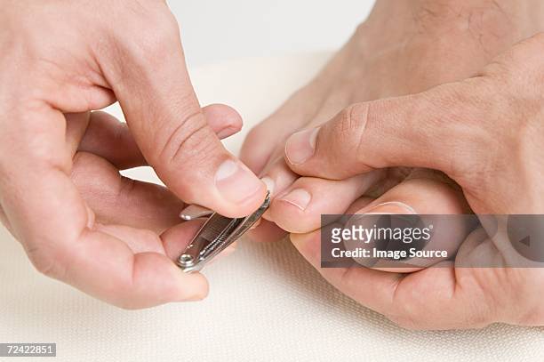 man clipping his toe nails - nagelklippare bildbanksfoton och bilder