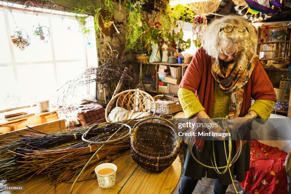 Woman weaving a basket in a weavers workshop.