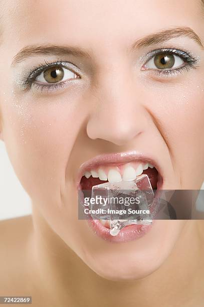 woman with an ice cube in her mouth - frost bite stock-fotos und bilder