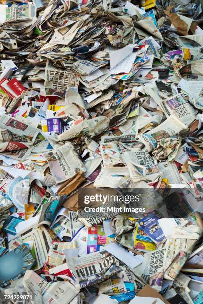 heap of recycled newspapers at a recycling centre. - newspaper stack stock pictures, royalty-free photos & images