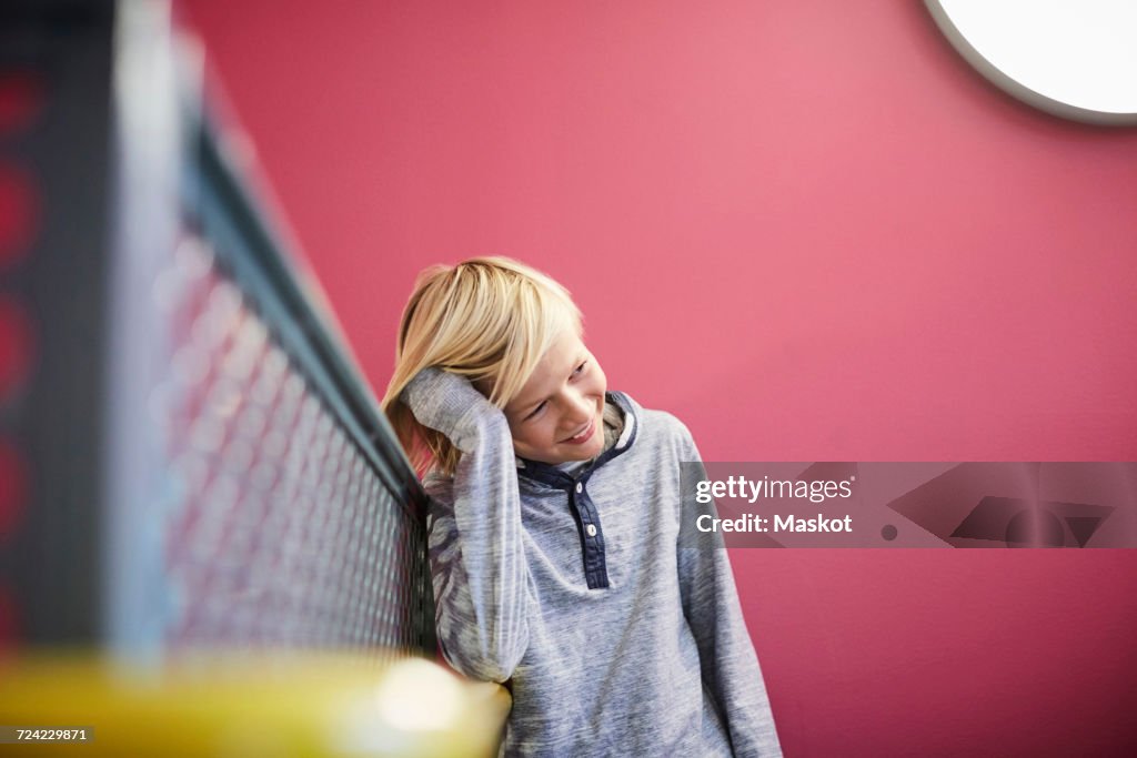 Thoughtful boy leaning on railing at middle school