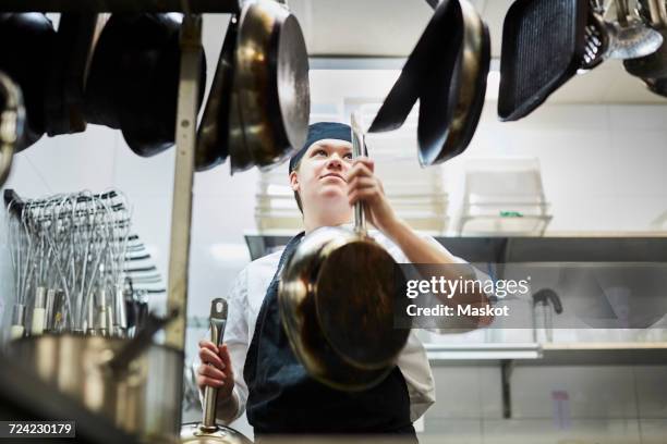 low angle view of chef arranging frying pan in commercial kitchen - choice student stockfoto's en -beelden