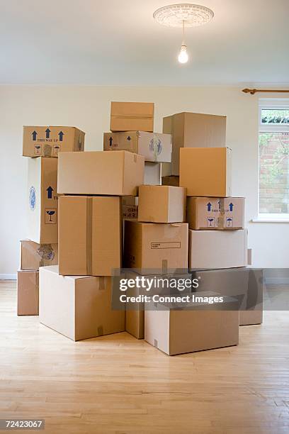 stack of cardboard boxes in a room - cardboard box stock pictures, royalty-free photos & images