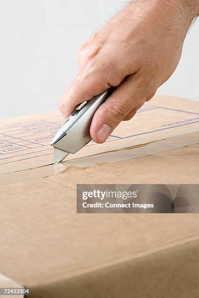 man opening box - utility knife stockfoto's en -beelden