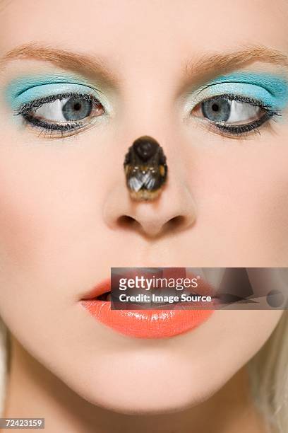 woman with a bee on her nose - scheel kijken stockfoto's en -beelden