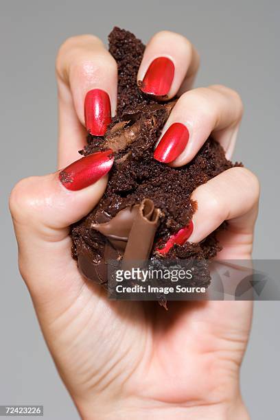 woman crushing cake in her hand - zerdrückt stock-fotos und bilder