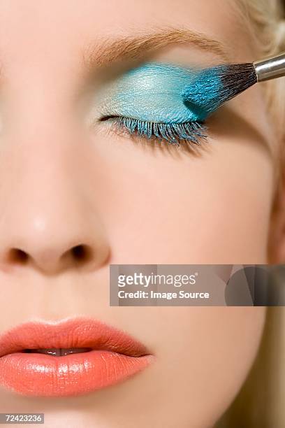 woman having eye shadow applied - applying makeup with brush fotografías e imágenes de stock