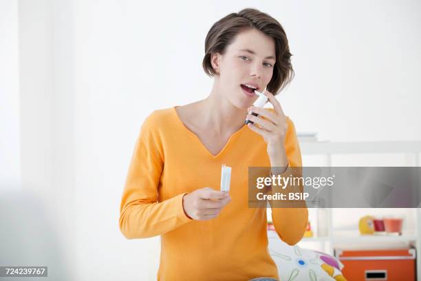 woman using spray in mouth - mouth spray stock pictures, royalty-free photos & images