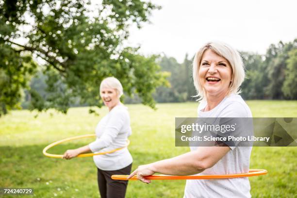 two women with plastic hoops - gymnastikreifen stock-fotos und bilder