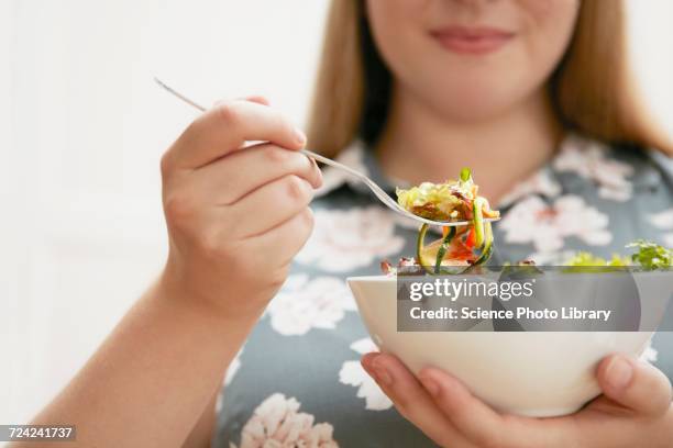 young woman eating bowl of salad - fat nutrient 個照片及圖片檔