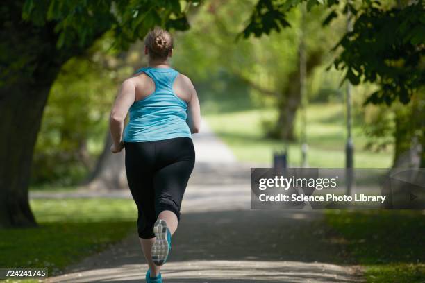young woman running on path, rear view - fat woman back stock pictures, royalty-free photos & images