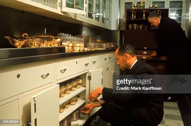 Head White House butler John Ficklin and assistant, Eugene Allen, take out the vermeil flat service prior to a state dinner for Princess Margaret and...