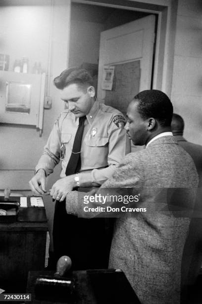 Civil rights leader Martin Luther King Jr. Being fingerprinted by police after his arrest during the Montgomery bus boycott.