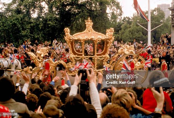 Crowds hailing Queen Elizabeth II as she and Prince Philip ride past in the Gold State Coach during the Queen's Silver Jubilee procession from...