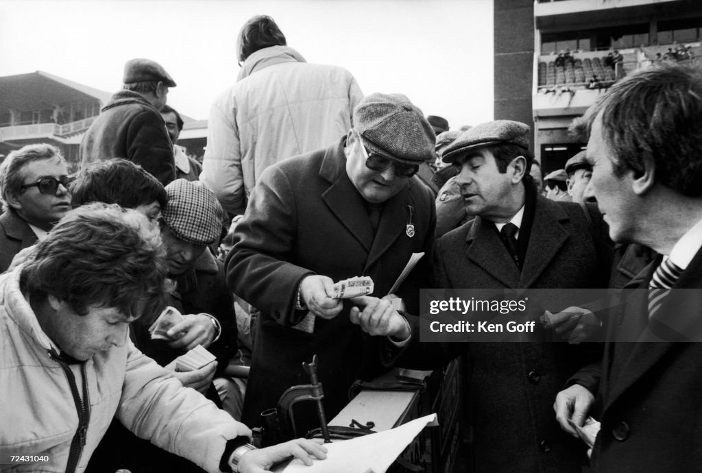 Bookmaker Sean Graham (C) of Belfast takes a bet at