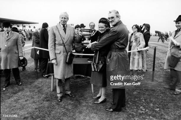 Irish horse owner John Mulhearn with unidentified, holding the Cheltenham National Hunt Challenge Cup.