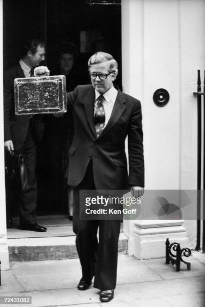 Sir Geoffrey How, Chancellor of the Exchequer, holding up the "budget box" while coming out of Downing street No. 11 on his way to present the budget...