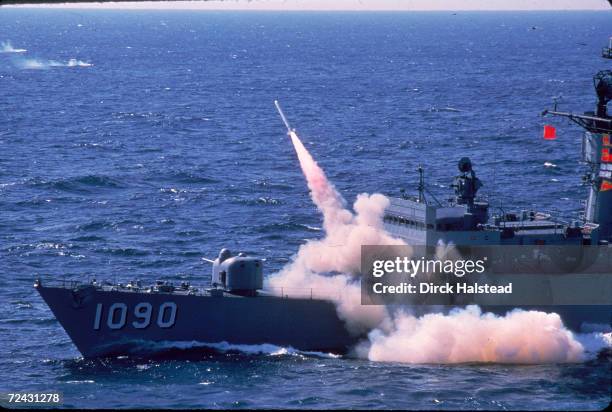 Harpoon anti-ship missile being fired from a fast fragate at sea.