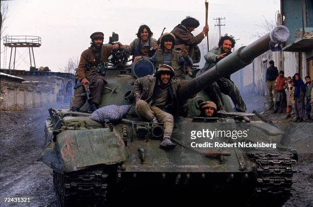 Jubilant Afghanistan govt. Troops aboard a Soviet T-62 tank during a battle with rival Shia Hezb-i-Wahadat mujahedin in S.with Kabul.