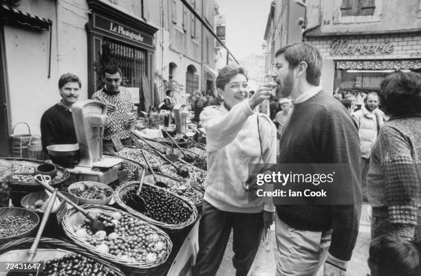 International Herald Tribune editor Walter Wells with wife Patricia, food critic, also tasting olives at market together at L'Isle-Sur-la-Sorque.