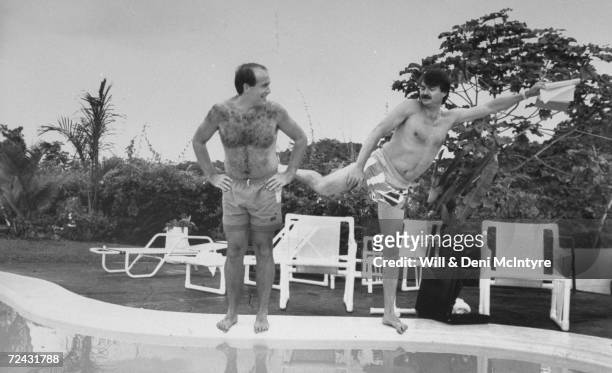 Jamaican Bobsled Olympic team Producer Bill Maloney getting kicked by friend & partner, George Fitch by swimming pool.