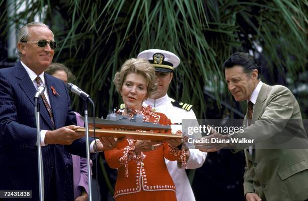 First Lady Nancy Reagan and Secretary of Defense Caspar Weinberger admiring a model of guided missile cruiser Ticonderoga.