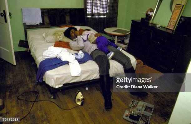 Unidentified African American teenage mother in ramshackled apt. With baby. .