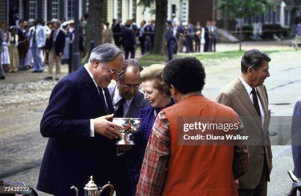 President Ronald Reagan, unid. Artisan, British PM Margaret Thatcher, interpreter Weber, and German Chancellor Helmut Kohl admire crafts during...